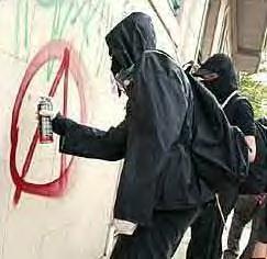 Dumbass in gas mask spraypainting anarchy sign on wall